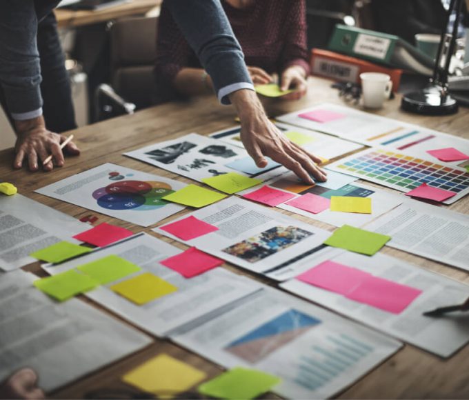 view of documents on a table with various colored sticky notes