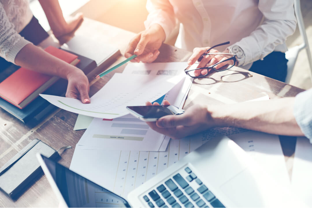 view of documents on a table with various individuals discussing the information